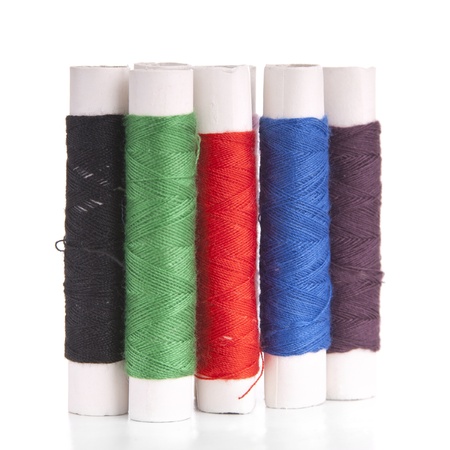 Reels of cotton thread in different colors isolated on white