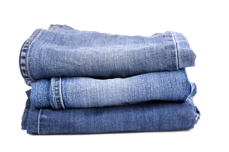 Blue jeans folded and stacked together, isolated on whiteの写真素材