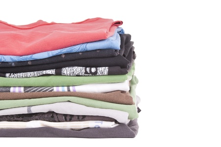 T-Shirts folded and stacked in variety of colors isolated on whiteの写真素材