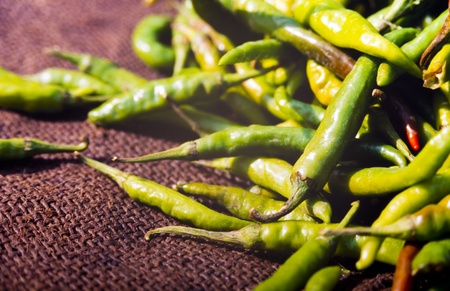 Fresh green chilli peppers at a market stall on hessianの写真素材