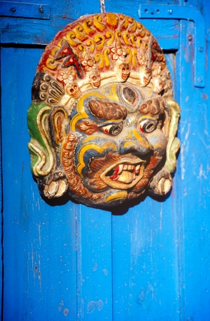 Wooden carving hung on a blue door in Nepalの写真素材