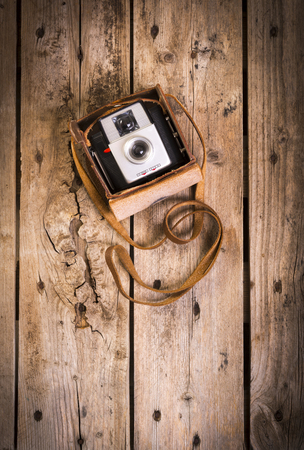 an old camera in its original vintage leather case on a woodenの写真素材