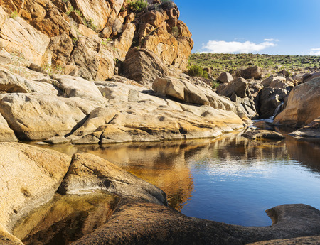 Water hole with tall cliffs in rural Australia's outbackの写真素材