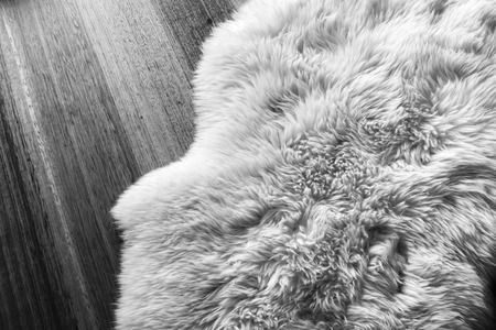 Lambs wool sheepskin on a timber floor in black and whiteの写真素材
