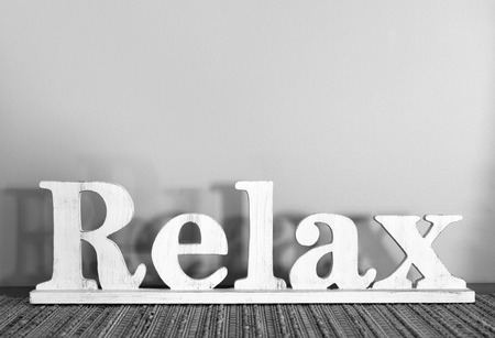 Relax written in large wooden letters with copy space in black and whiteの写真素材