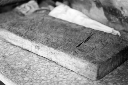 Old vintage chopping board in outdoor kitchen with very shallow focus in black and whiteの写真素材