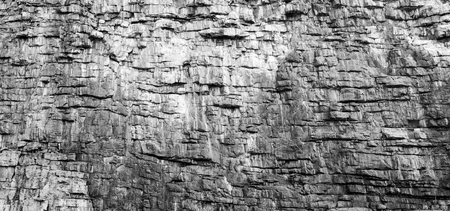 Rock face texture of large rocky cliffs in black and whiteの写真素材