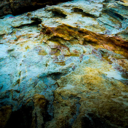 Wet rocks at dawn form a colourful abstract background