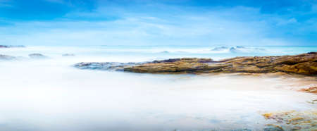 Calm ocean landscape time-lapse with smooth waves and rocksの写真素材