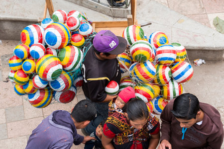 SAN JUAN OSTUNCALCO, GUATEMALA - JUNE 24: Colorful balls carried by an unidentified vendor through crowds at the San Juan Ostuncalco fair in honor of Saint John the Baptist on June 24, 2017 in Guatemala.のeditorial素材