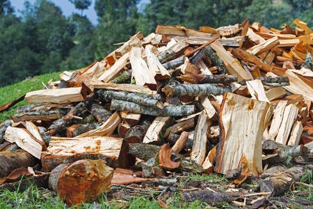 Firewood pile of roughly chopped wood for winter in the countrysideの写真素材