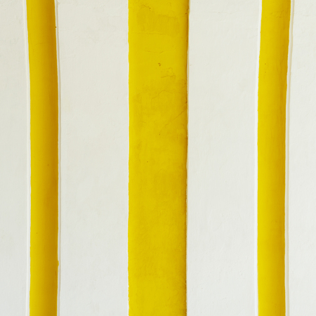 Yellow stripes background on a Spanish colonial wall in Central Americaの写真素材