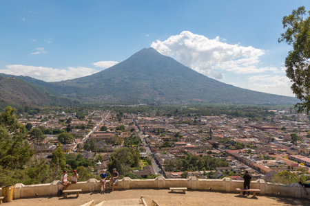 ANTIGUA, GUATEMALA - FEBRUARY 24, 2018: Unidentified people at the Cerro de la Cruz lookout above the tourist town of Antigua, Guatemala with Volcan de Agua behind.のeditorial素材