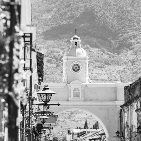 Antigua Guatemala, classic colonial town with famous Arco de Santa Catalina and Volcan de Agua behind in stunning black and whiteの写真素材