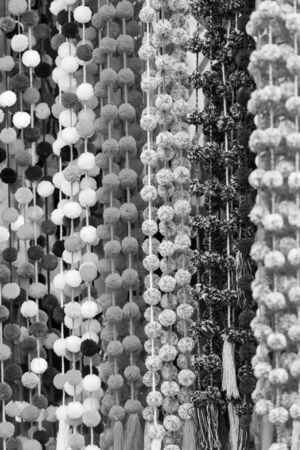 Decorative pom-poms hanging in a Chiapas market as a background texture in stunning black and whiteの写真素材