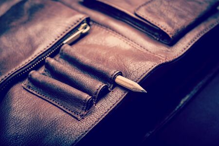 A man's business briefcase bag, leather satchel with a pencil with retro style filter effectの写真素材