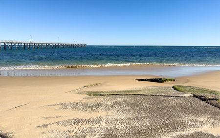 Classic wooden Port Noarlunga Jetty stretches out into the ocean in Adelaide, South Australiaの写真素材