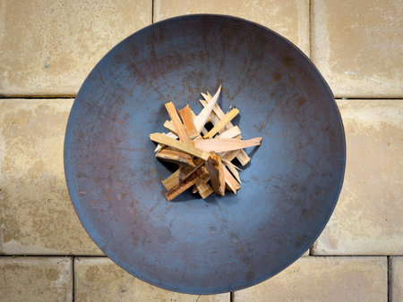 Round metal fire pit with wood kindling top view in outdoor patioの写真素材