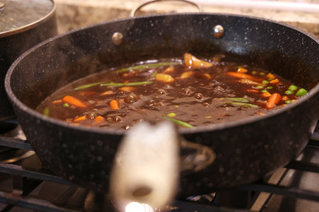 cooking beef and vegetables in a wok on a gas stoveの写真素材