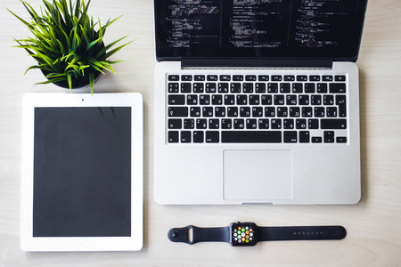 Modern design concept of creative workplace, smart watch, laptop, tablet, flower