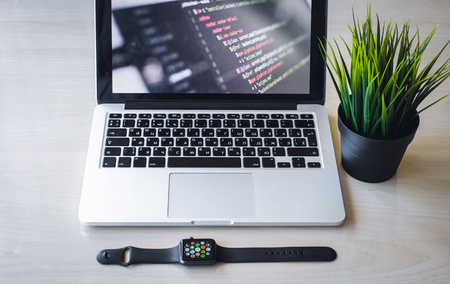 Modern design concept of creative workplace, smart watch, laptop, tablet, flower