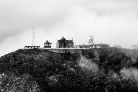 house on top of the mountain in a foggy dayの写真素材