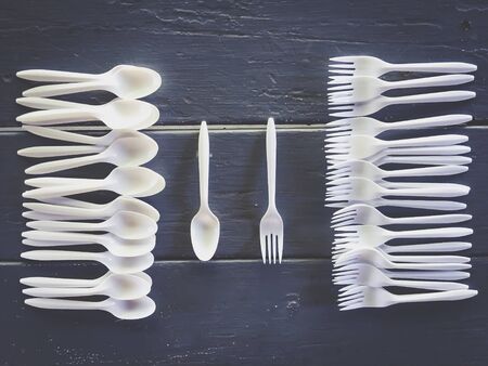 plastic forks and plastic spoons with wooden tableの写真素材