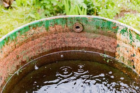 Metal barrel in the rainの写真素材