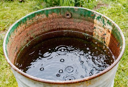 Metal barrel in the rainの写真素材