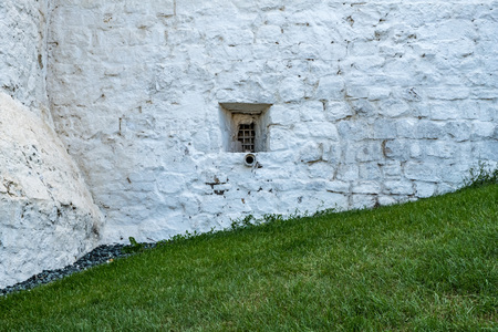 Small window in the stone wall of the ancient Kremlin