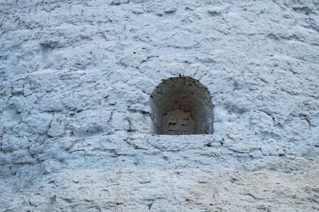 Small window in the stone wall of the ancient Kremlin