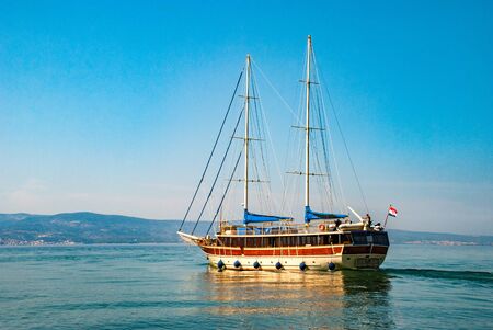 Large sailing ship with deflated sails facing the sea