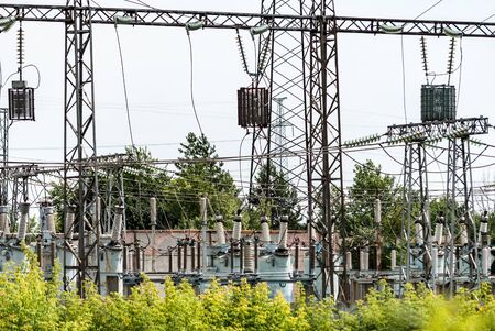 High-voltage power plant in the green zone against the background of a cloudy skyの写真素材