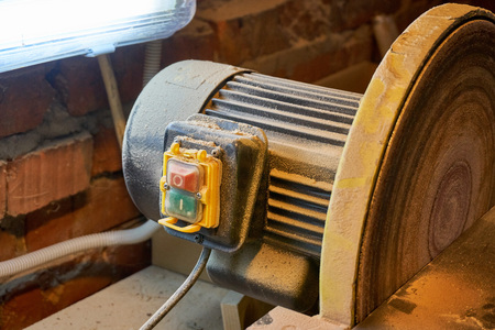 Grinding wheel with a lamp in the dust after workの写真素材
