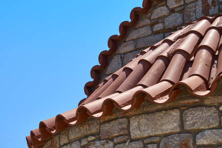 Tiled roof of a small chapel with stone wallsの写真素材