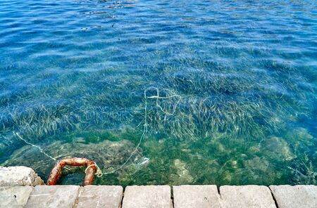 Concrete sea mooring for small boats with a rusty hookの写真素材