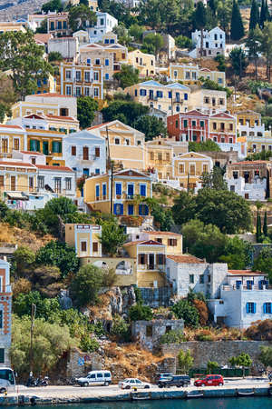 Multi-colored houses on the rocky coast of Simi Islandの写真素材
