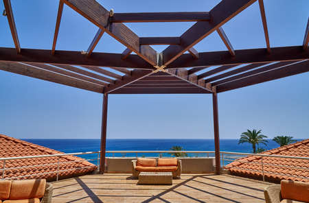 Terrace with wooden pergola and orange sofasの写真素材