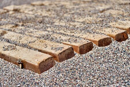 Wooden flooring on small pebbles on the beachの写真素材