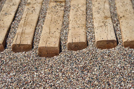 Wooden flooring on small pebbles on the beachの写真素材