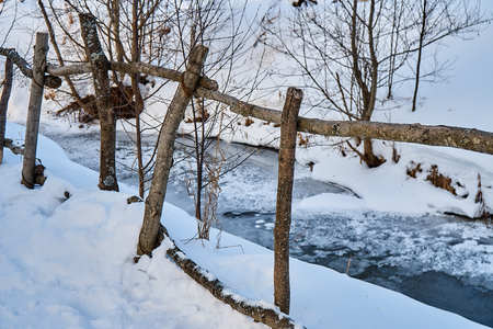 Wooden fence made of thin logs is made in the old styleの写真素材