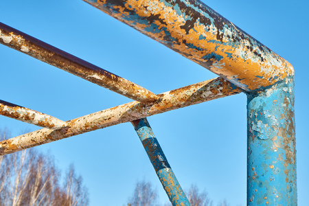 Old rusty horizontal bar against the blue sky