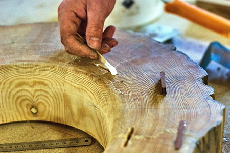 Close-up of the insertion of dowels in a joinery workshop