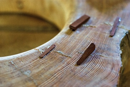 Close-up of the insertion of dowels in a joinery workshop