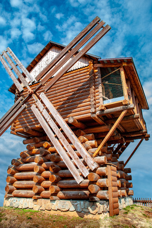 Old wooden windmill against the blue sky in the countryside