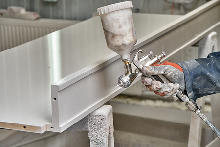 Painting cabinets with spray gun. Painting chamber, spray gun. Wooden furniture manufacturing processの写真素材