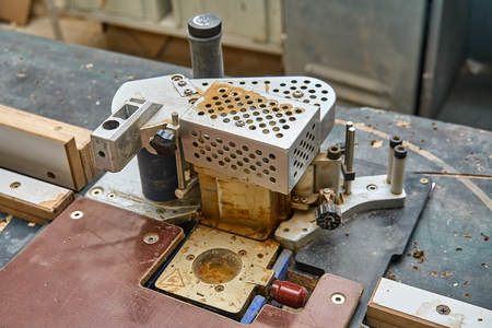 Edge banding machine in the workshop. Close-up. Wooden furniture manufacturing process