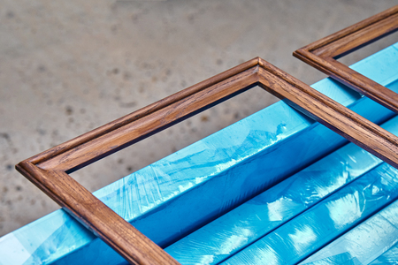 Wood door manufacturing process. Wooden moldings for the entrance door, painted in dark color....