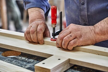 Joinery. Carpenter clamping plywood parts. Woodworking and carpentry production. Furniture...