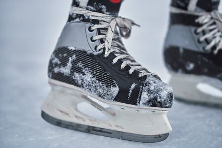 Hockey skates on the player feet after ice hockey. Close-up